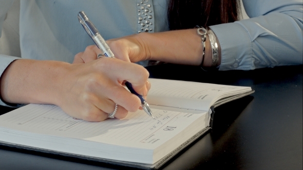 Female Hand Writing In Notebook alt