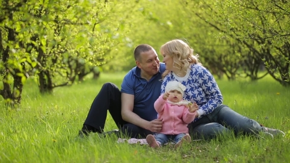 Happy Family Sitting On Nature