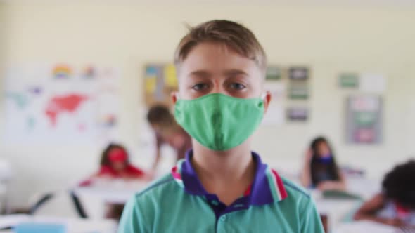 Portrait of boy wearing face mask in class at school