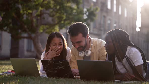 Joyful Classmates with Laptops Studying in Nature