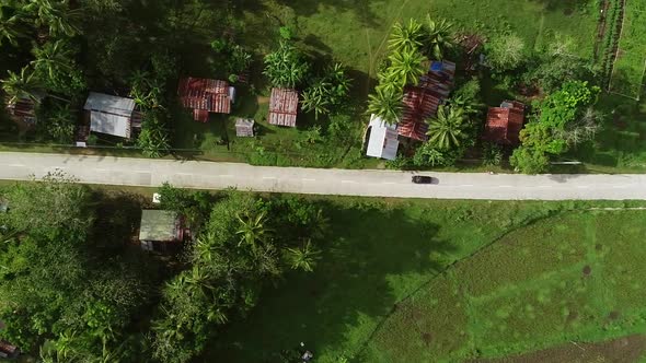 Aerial view following car on road. Chocolate Hills Complex, Batuan, Philippines.