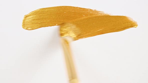 Abstract Brushstrokes of Gold Paint Brush Applied Isolated on a White Background