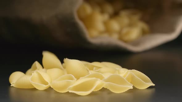 Pasta (Conchiglie) Fall Near A Lying Cloth Bag