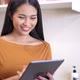 Young woman relaxing standing in kitchen and using digital tablet. - VideoHive Item for Sale