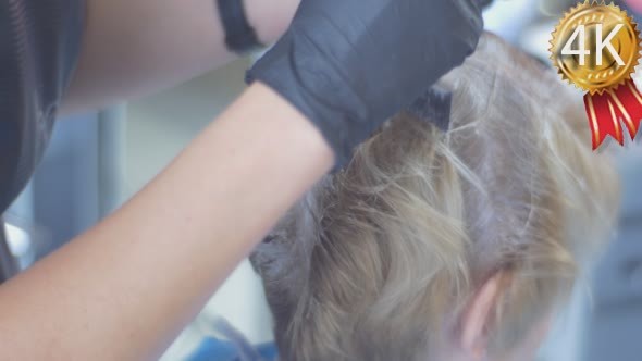 Hairdresser Stylist Makes Hair Coloring Blonding