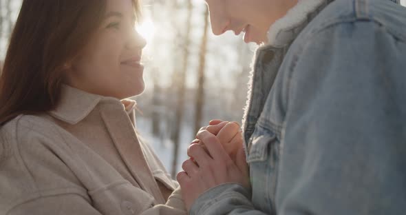 Happy Young Beautiful Couple Spend Time in Sunny Winter Forest Together