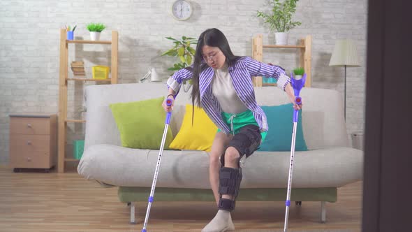 Portrait Young Asian Woman After Injury Knee Bend Orthosis Knee Brace Using Crutches Gets Up From