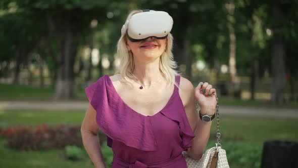 Zoom in Slow Motion to Smiling Happy Adult Woman in VR Headset Standing in Sunny Summer Park