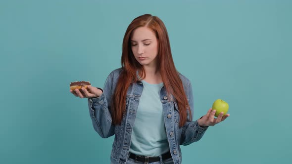 Young Woman Choosing Between Apple and Cupcake the Girl Is Confused in Her Choice