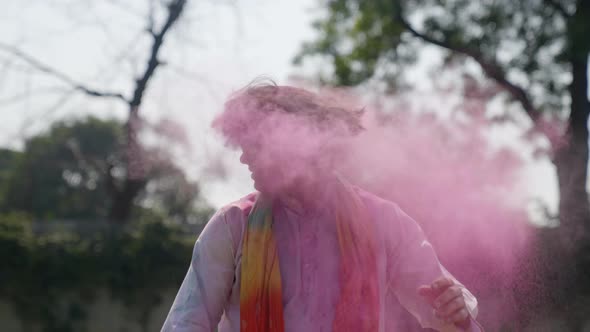 Indian man playing holi and swinging his hairs