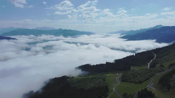 Drone flight above low hanging clouds blanketing a valley in Austria.