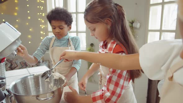 Kids Adding Flour to Mixer Bowl on Culinary Masterclass