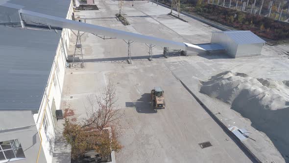 Aerial of a factory and an excavator