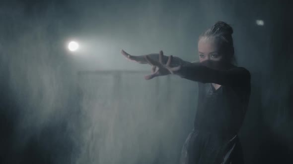 Portrait of a Young Talented Ballerina in Black Dress Arching and Throwing Flour