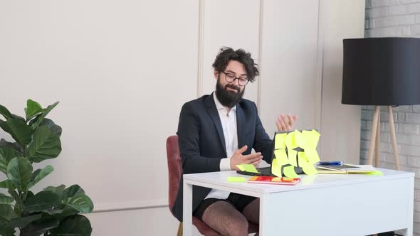 Bearded Man Comfortable at His Desk in Underwear and Jacket Working Remote