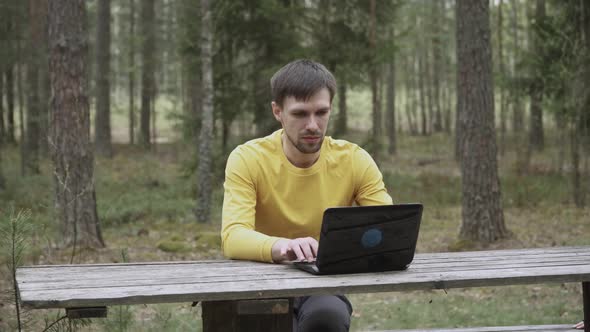 Man with Stubble Looks at Laptop Screen