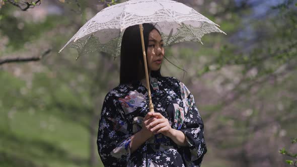 Portrait of Charming Asian Beautiful Young Woman Standing with White Sun Umbrella in Spring Park