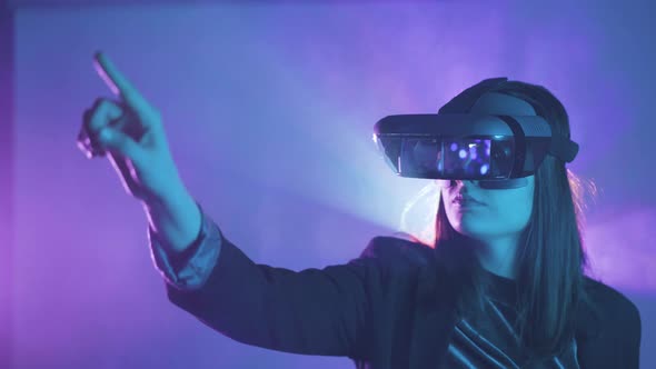 Anonymous woman in VR goggles in neon light