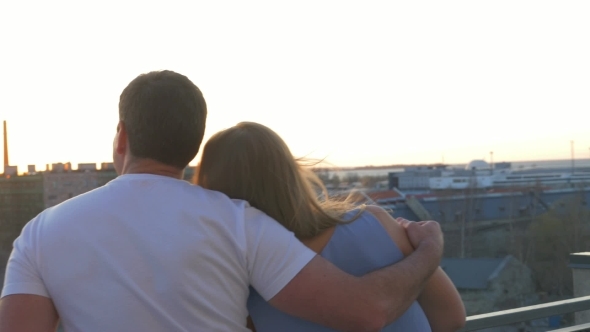 Romantic Couple On The Balcony Look At The City