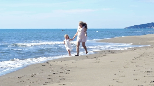 Mother And Daughter Playing On The Beach 