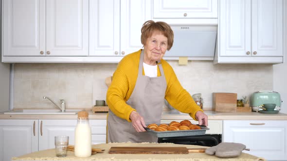 Happy Senior Woman Baking Pastry In Her Home Kitchen