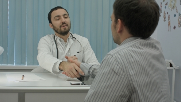 Male Bearded Doctor In Clinic With Male Patient