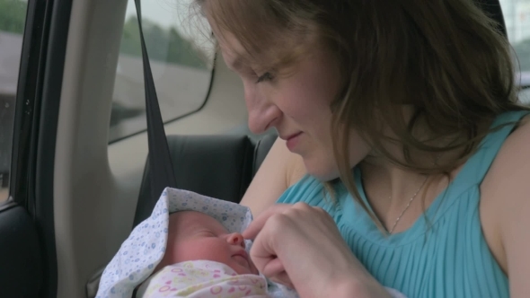 Mother With Newborn Baby In Car