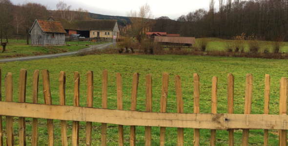 Old German Houses in Field and Wooden Fence