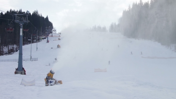 Skiers Ride On The Ski Slopes And Snow Cannons