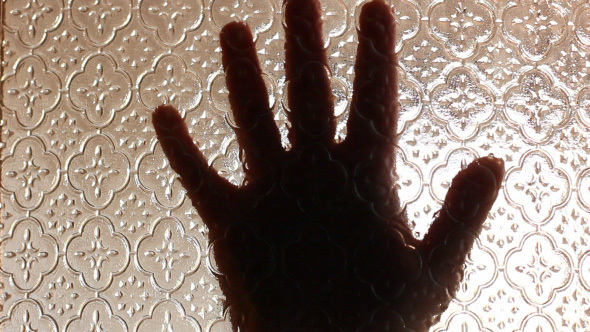 Terrified Hands Of Victim Behind The Glass