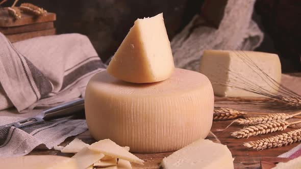 Pieces of fresh homemade cheese on a wooden board with a cheese knife close up