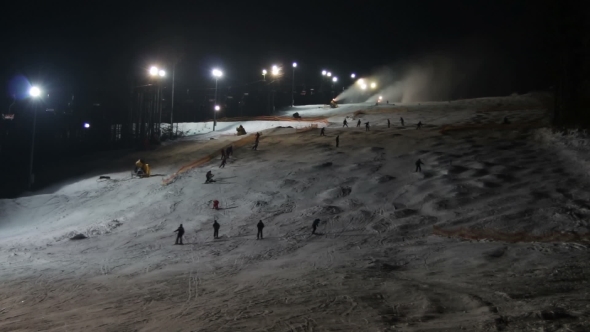 Skiers Ride On The Ski Slopes And Snow Cannons.