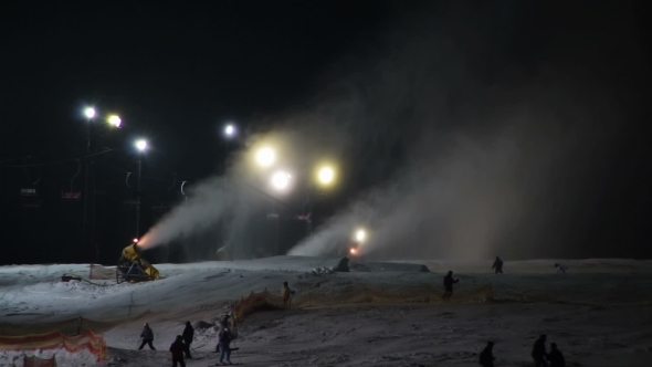 Skiers Ride On The Ski Slopes And Snow Cannons.