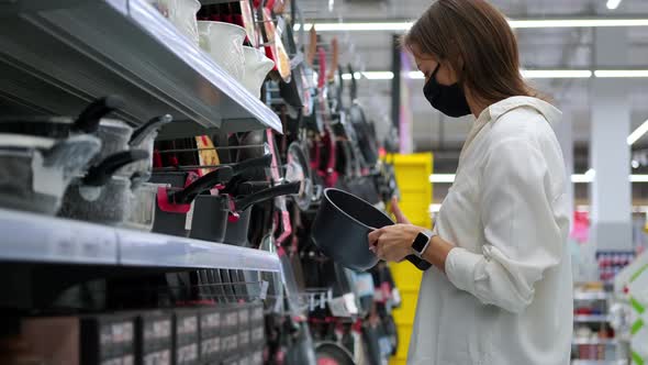 Female Customer of Supermarket is Choosing Pan in Kitchen Tableware Department