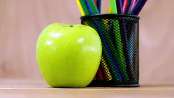 Pen holder with color pencil and apple