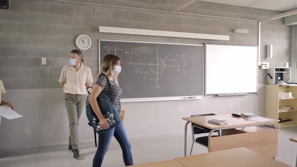 The Teacher Welcomes the Students Who Enter the Classroom Wearing Protective Masks