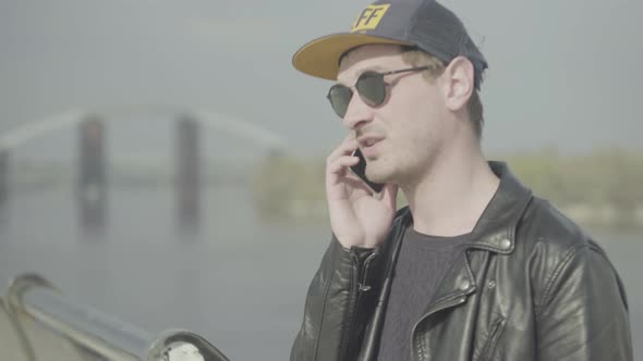 The Guy Speaks on a Cell Phone and Smokes