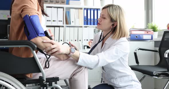 Woman Doctor Measuring Blood Pressure of Pregnant Disabled Woman in Wheelchair  Movie