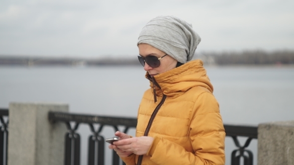 Beautiful Woman Texting On Smartphone Beside River