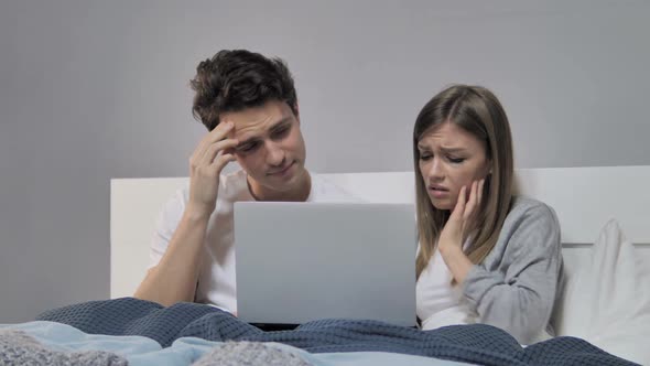 Young Couple in Bed Reacting to Failure