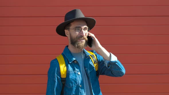 Hipster Young Man Talking on the Phone in a Urban Background.