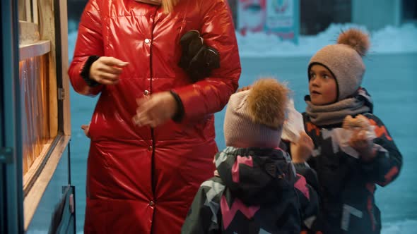 Young Blonde Woman with Her Children Drinking Hot Drinks