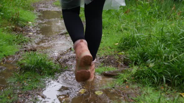 Close Up Woman Legs in Pink Hiking Boots Walking By Rain Puddleswet Green Grass