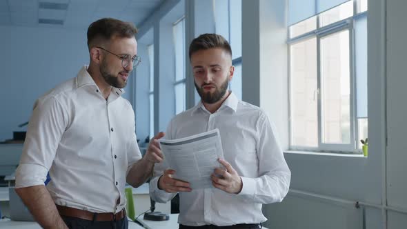 Bearded Men Speak About Paper Work in an Office