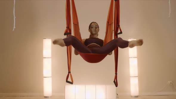 Girl Hanging Upside Down in Hammock. Lady Doing Inverted Pigeon Pose in Hammock