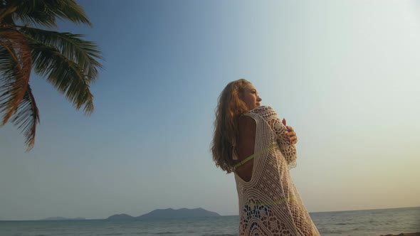 Woman in a White Tunic on Beach Near the Sea Palm Tree