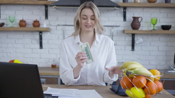 Blond Cheerful Woman Counting Money Talking and Smiling
