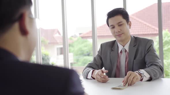 Businessman giving money while making deal to buy new house