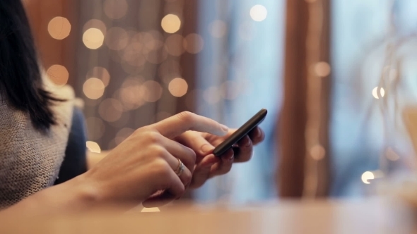 Beautiful Woman Using  Smartphone In Cafe. 