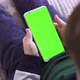 Smartphone in Hand with a Green Screen The Child Is Holding a for Keying Close-up Playing a Game - VideoHive Item for Sale